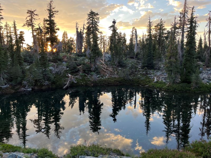 Mountain scene with sun setting in the background.